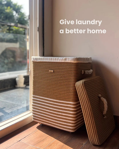 Brown and beige striped laundry basket with a handle on a wooden floor